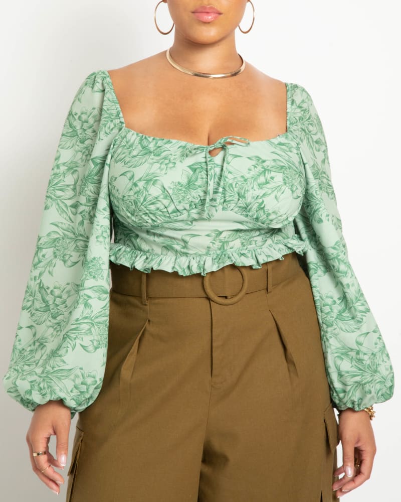 Front of a model wearing a size 14 Grace Puff Sleeve Blouse in Outdoor Type Green by ELOQUII. | dia_product_style_image_id:215260